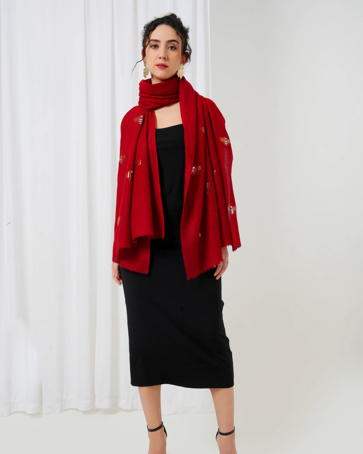 Woman wearing a red scarf with a white curtain background
