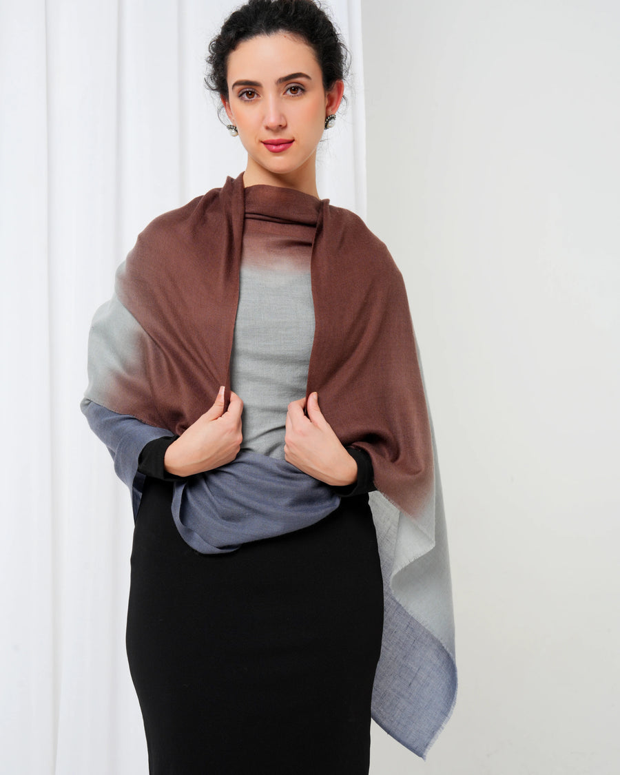 Woman wearing a brown and gray gradient shawl against a white background