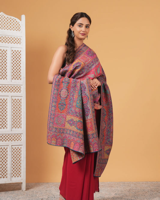 Woman holding a patterned scarf against a beige wall