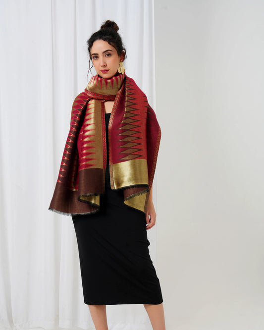 Woman wearing a red and gold patterned scarf against a white background