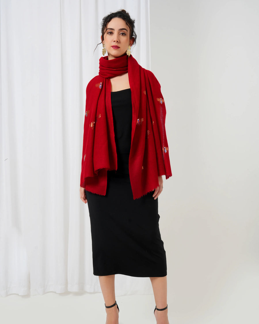 Woman wearing a red scarf with a white curtain background
