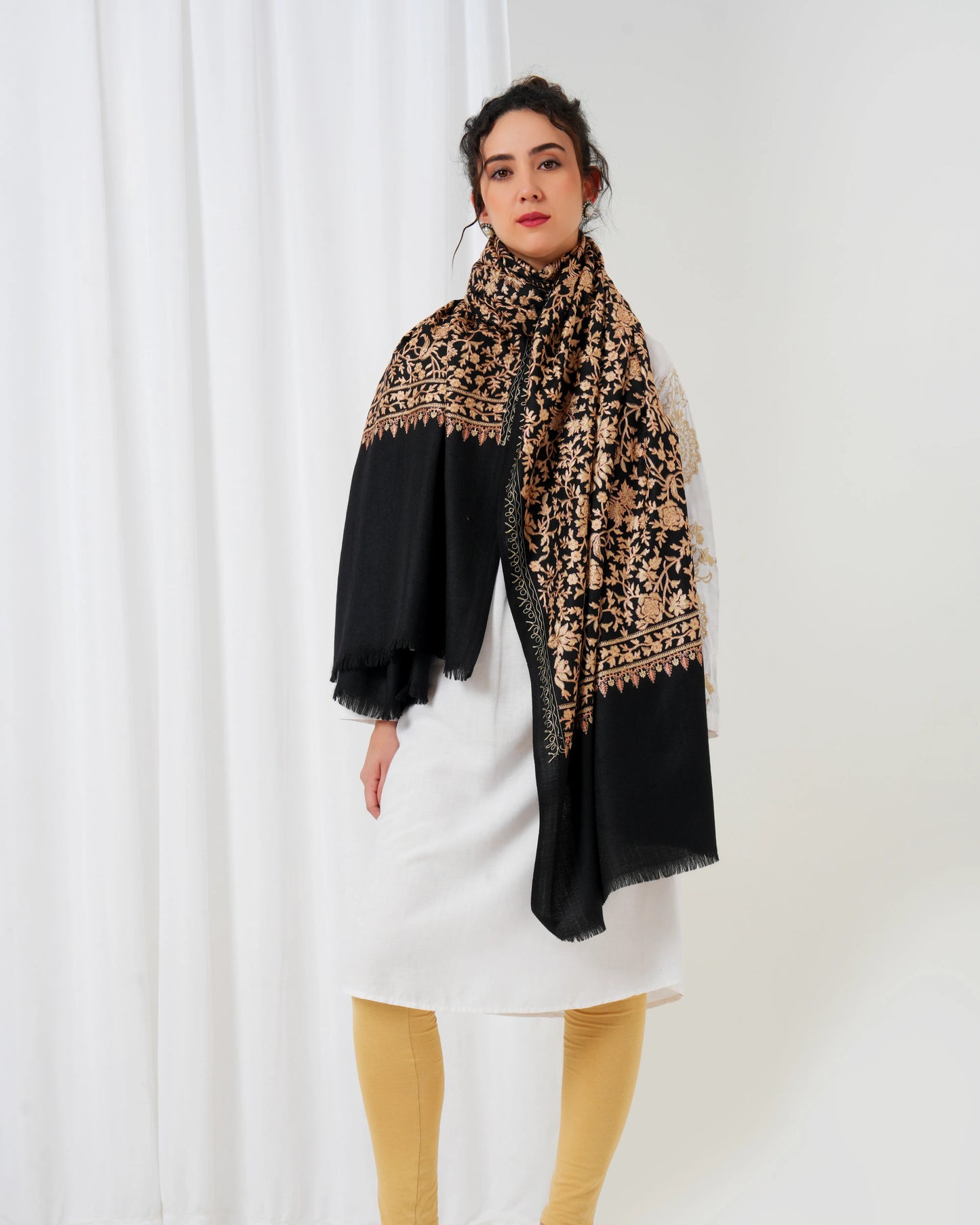 Woman wearing a black and beige patterned scarf on a white background