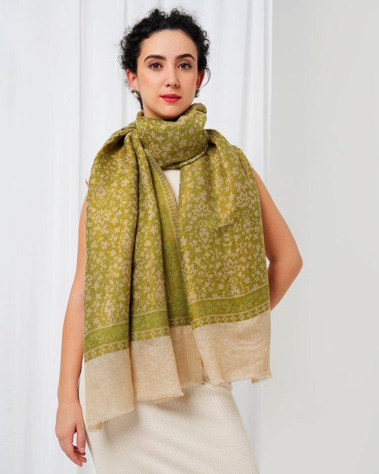 Woman wearing a green and beige scarf against a white background