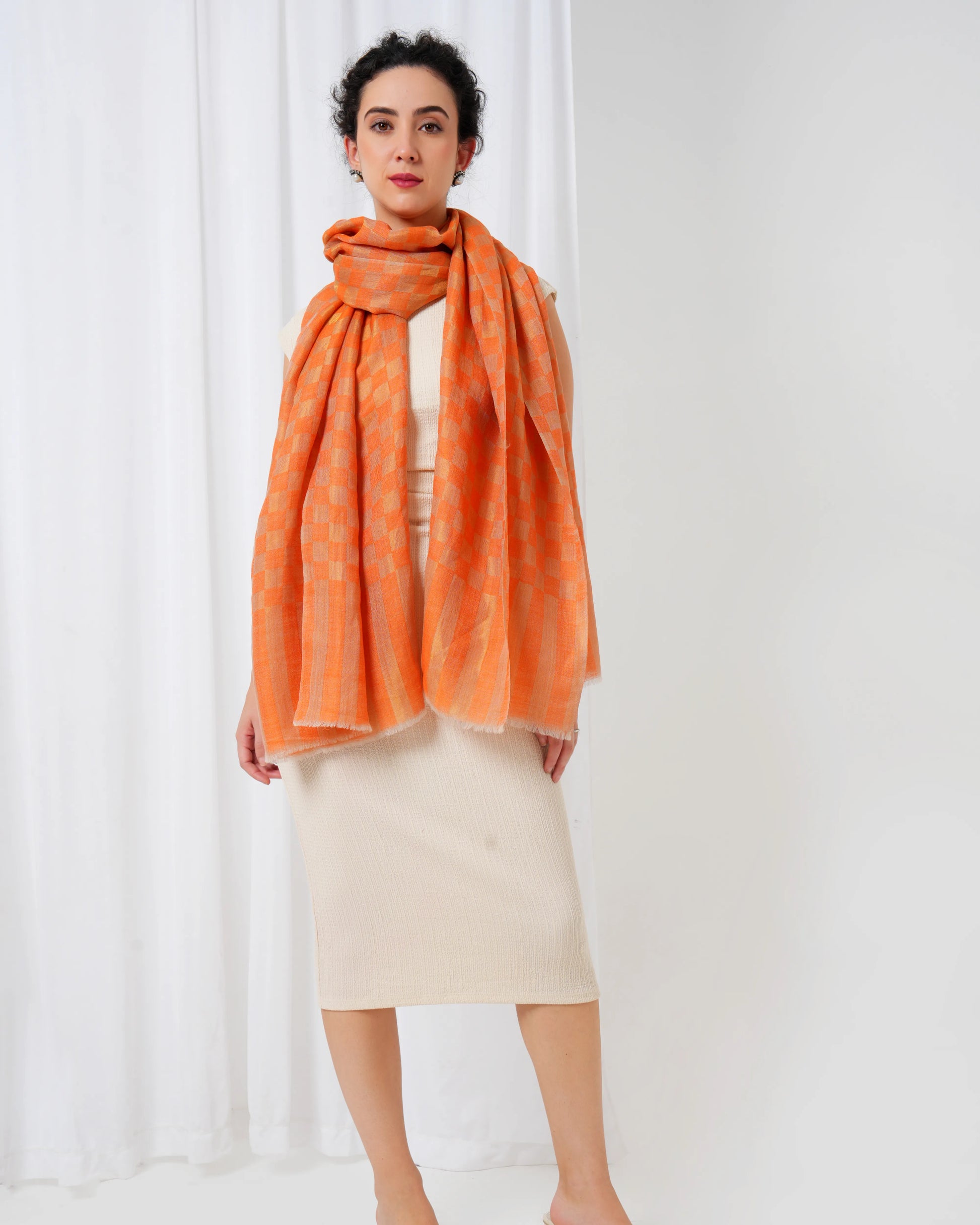 Woman wearing an orange scarf against a white background