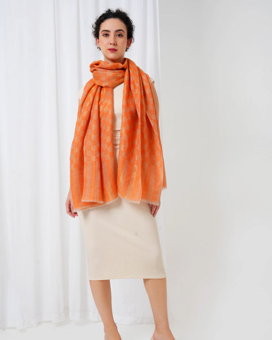 Woman wearing an orange scarf against a white background