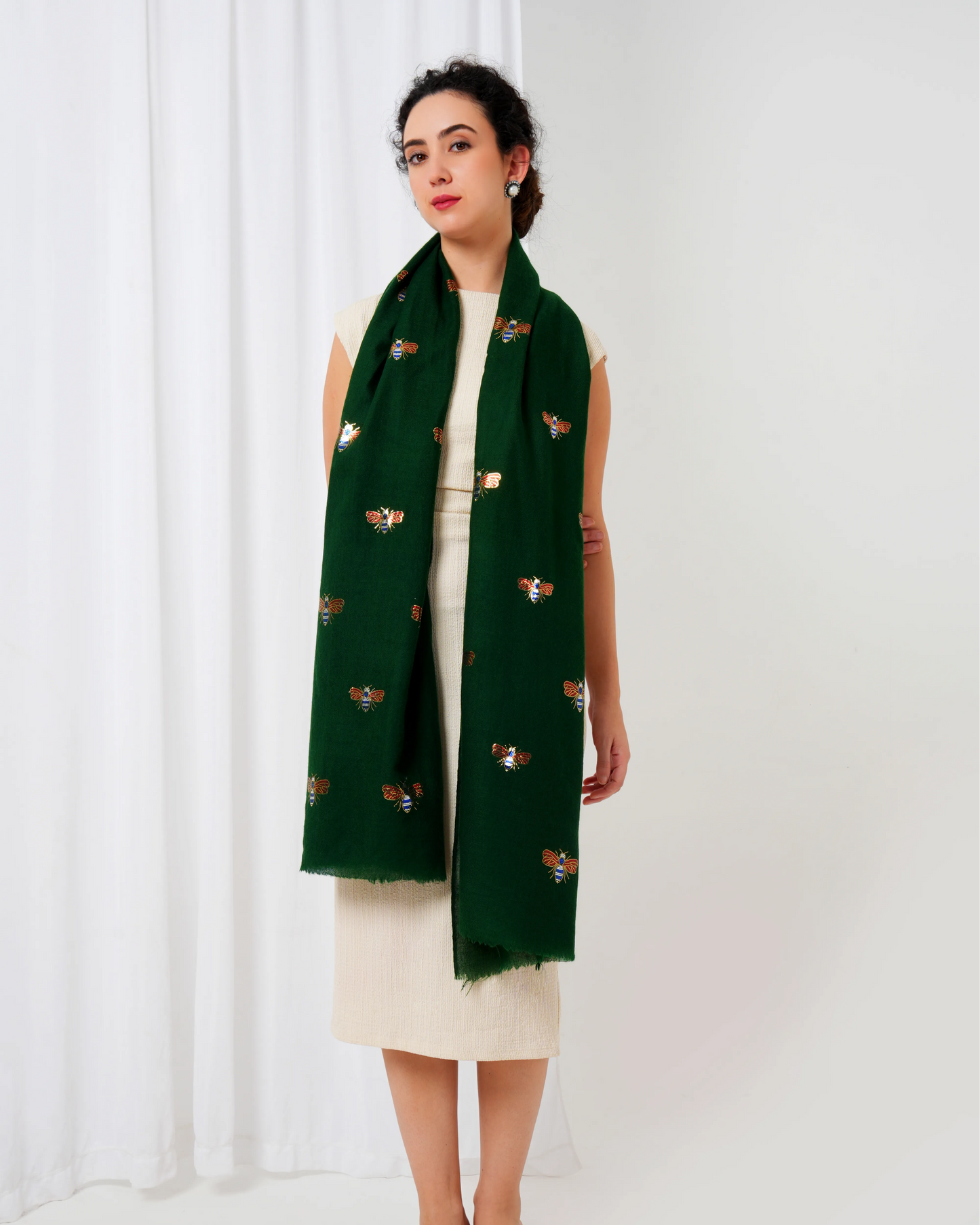 Woman wearing a green scarf with butterfly patterns on a white background
