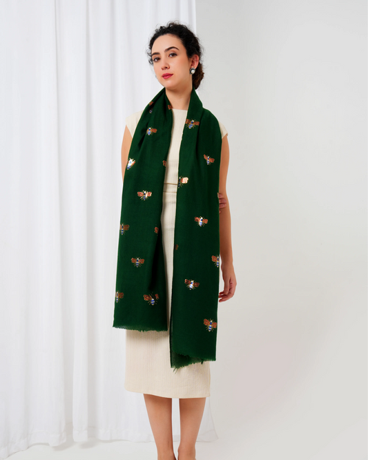 Woman wearing a green scarf with butterfly patterns on a white background