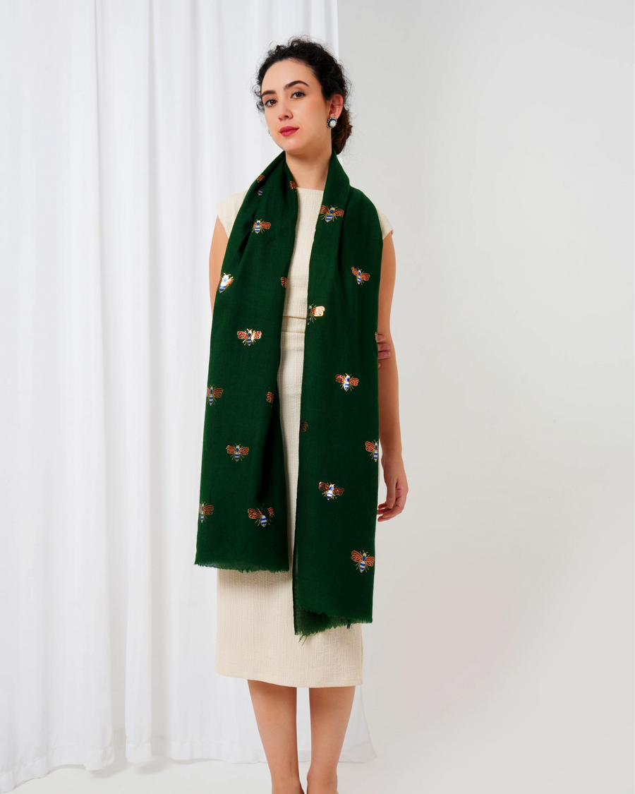 Woman wearing a green scarf with butterfly patterns on a white background