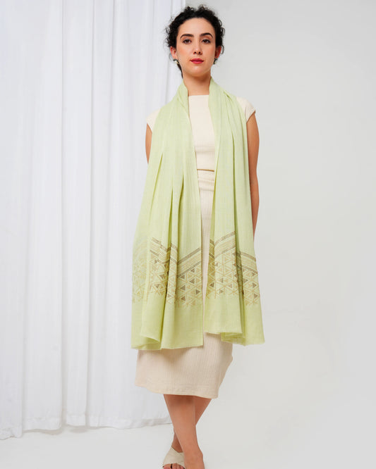 Woman wearing a light green scarf over a white dress against a white background
