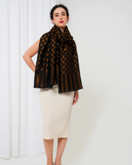 Woman wearing a brown and black patterned scarf against a white background