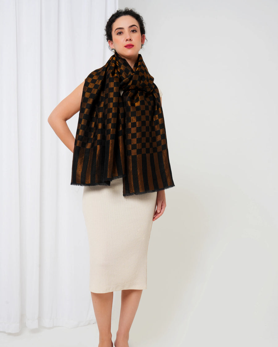 Woman wearing a brown and black patterned scarf against a white background
