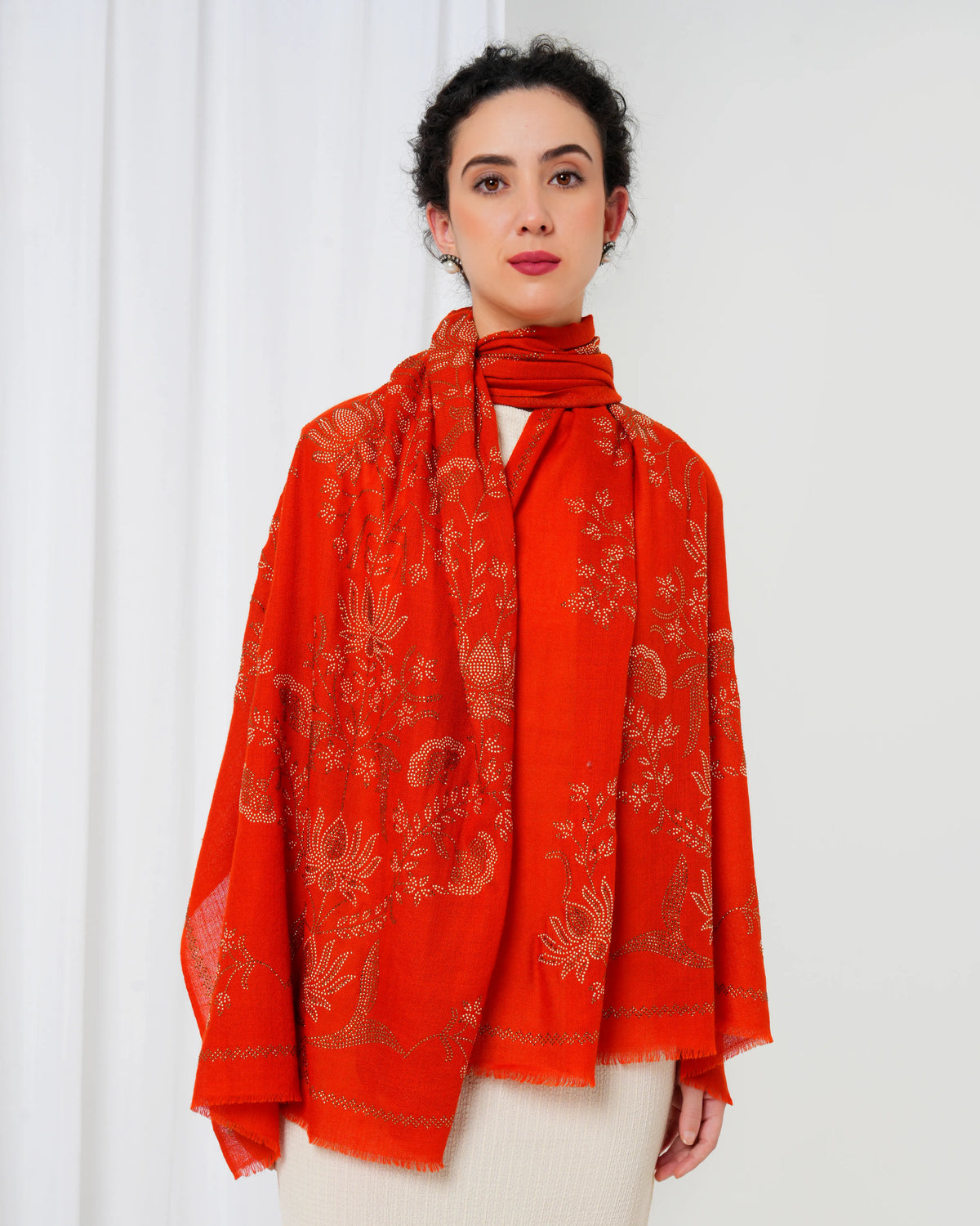 Woman wearing a red patterned scarf against a white background