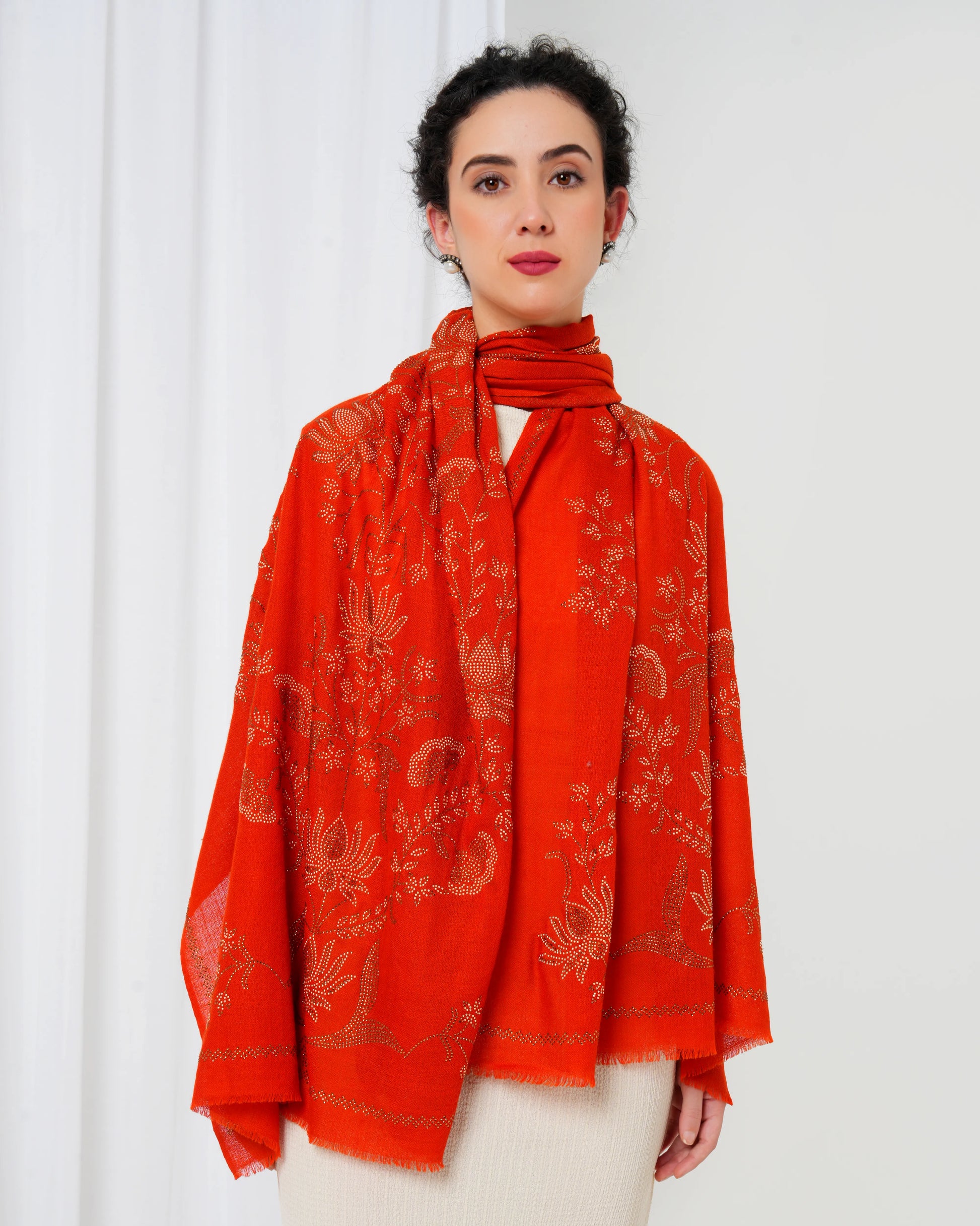 Woman wearing a red patterned scarf against a white background
