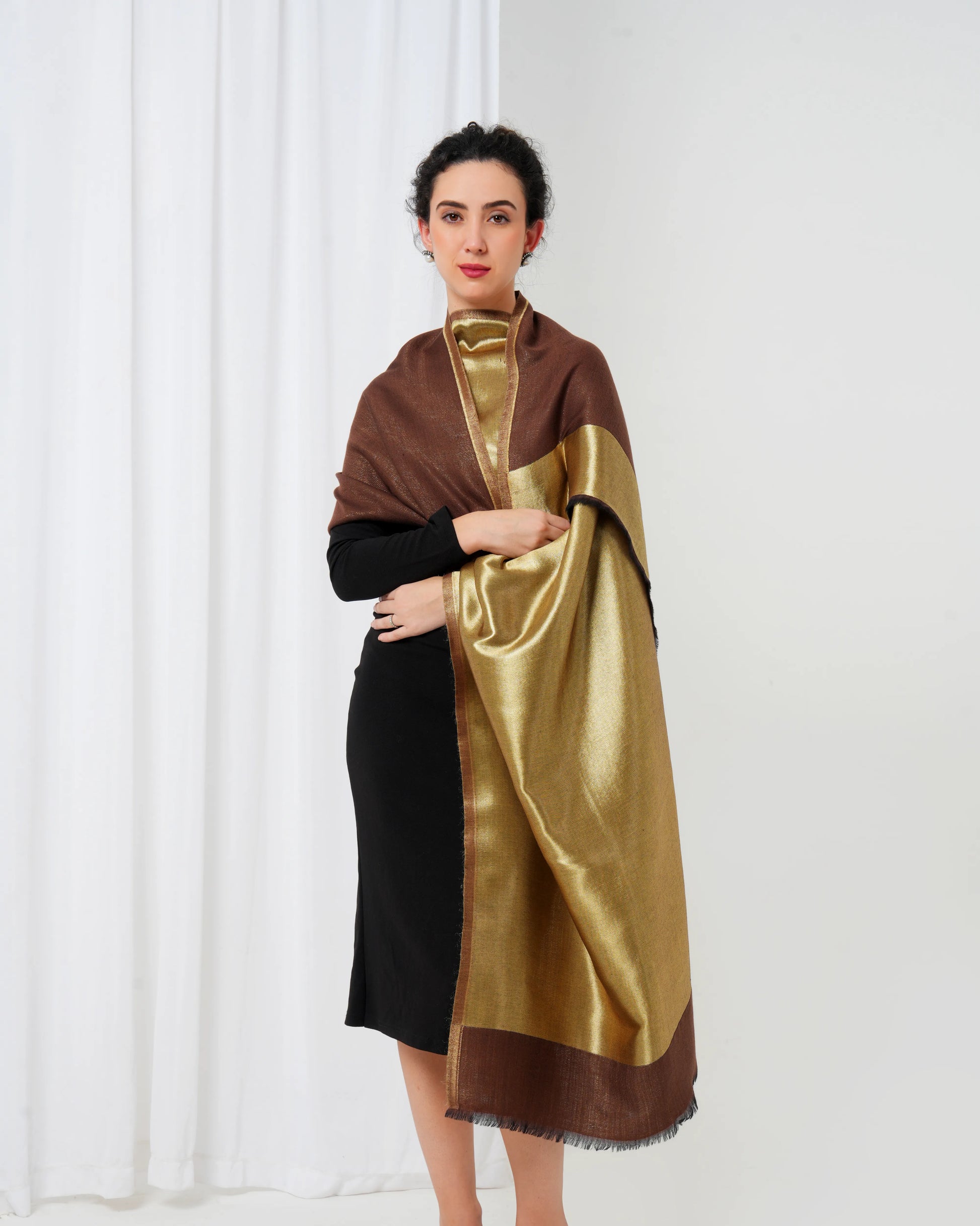 Woman wearing a brown and gold scarf against a white background