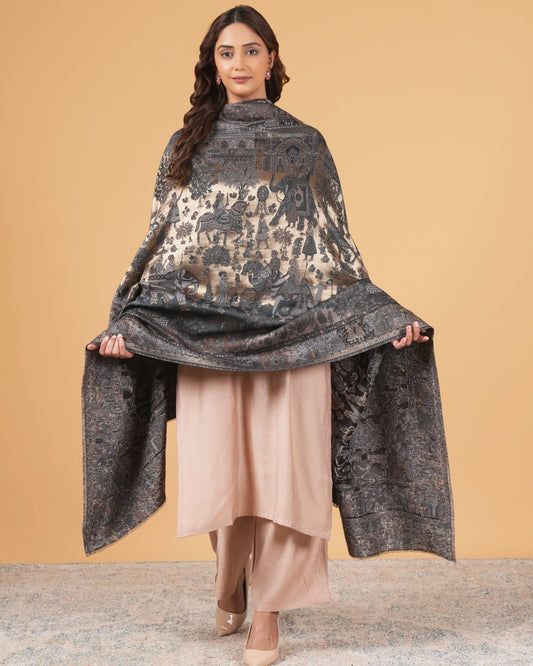 Woman wearing a dark patterned shawl over a beige outfit against a beige background