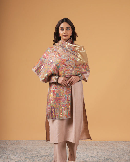 Woman wearing a traditional outfit with a patterned shawl against a beige background