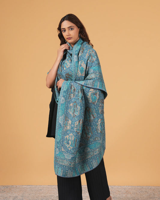 Woman wearing a blue patterned coat against a beige background