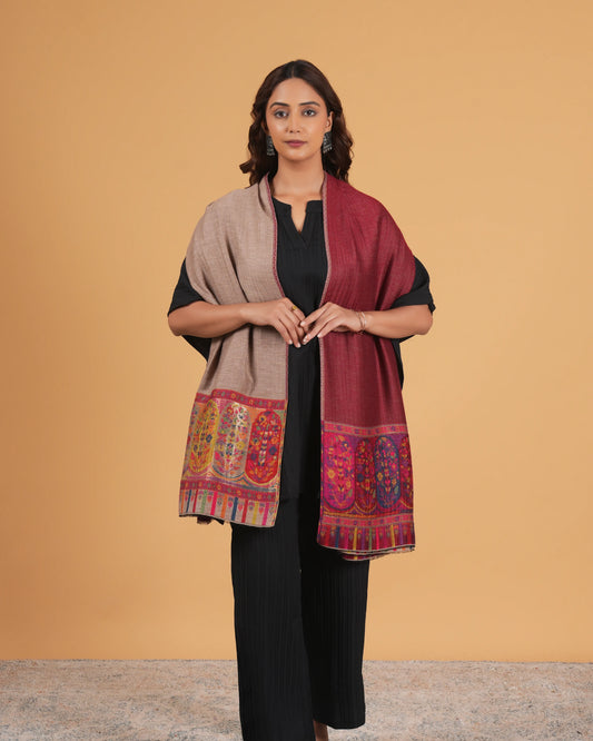 Woman wearing a patterned shawl over a black outfit on a beige background